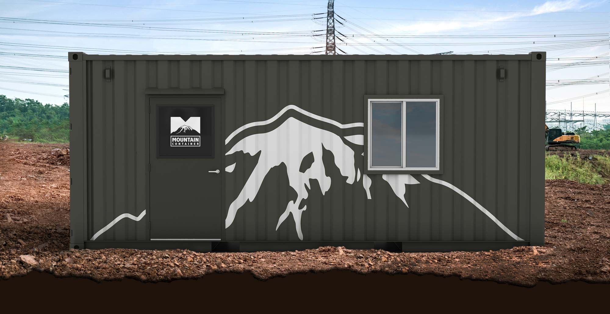 Grey branded shipping container with a door and window sitting on the dirt ground at a construction site.