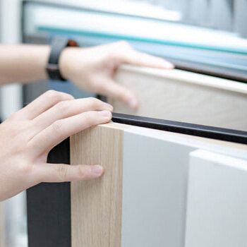 Person flipping through white, wood and black standing cabinet door samples 