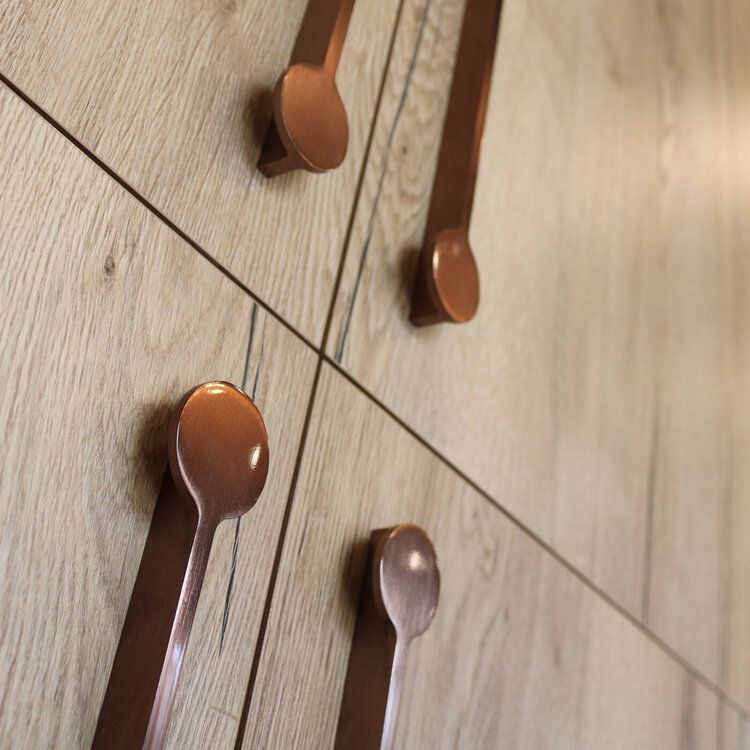 Light wood cabinets with copper spoon shaped handles