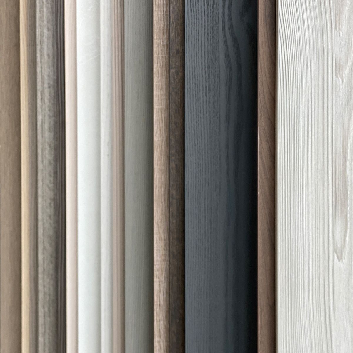 Examples of different color wood samples from white, blue, green and shades of brown.