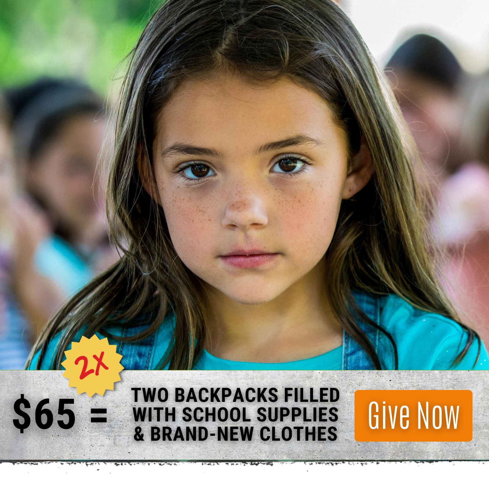 Young girl in classroom. Click to donate and provide backpacks filled with school supplies and brand new clothes. 
