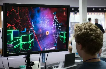 Teenage Boy playing video game in the game room at the convention