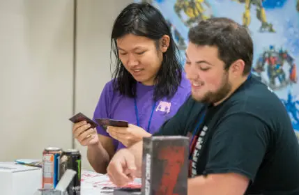 Two men playing magic the gathering in the game room at Kingcon