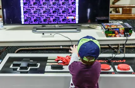Little Boy playing a game on a giant Nintendo Nes Controller