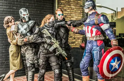 Group of Cosplayers posing, Captain America fending off cosplay villans to save Peggy