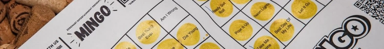 Close up image of a mingo card on a bed of corks. The card is partially filled out with a gold marker.