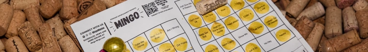 Close up image of a mingo card on a bed of corks. The card is partially filled out with a gold marker.