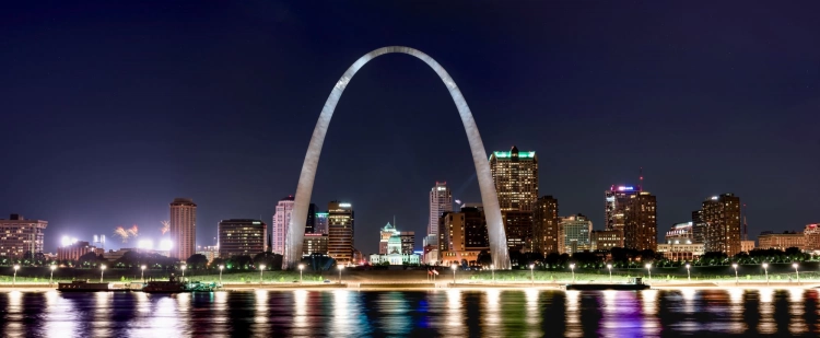 Gateway to Giving St. Louis Arch image at night with lights reflecting off the water